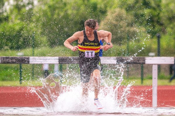 Man landing in water with splash from steeplechase jump
