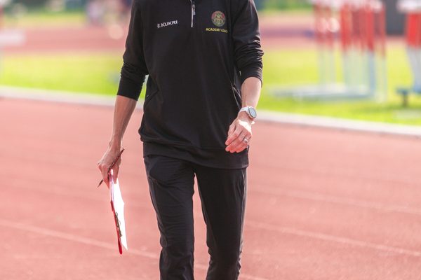 Ladies in Walton AC tracksuit with clipboard on an athletics track
