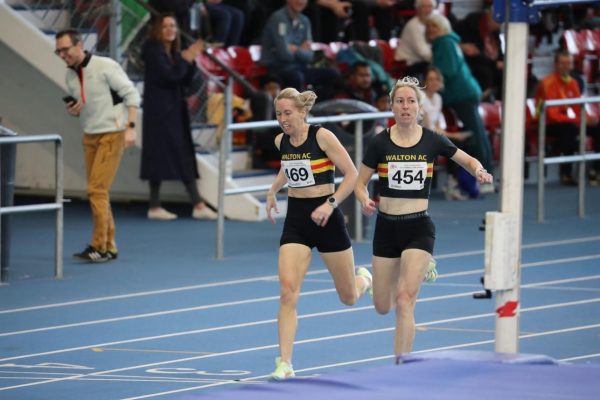 Women running on an indoor athletics track