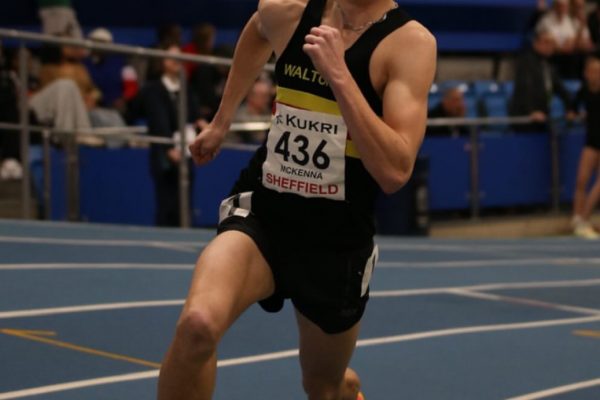 Man running on an indoor athletics track
