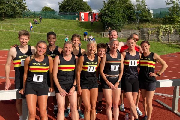 Group of athletes in Walton vests on an athletics track