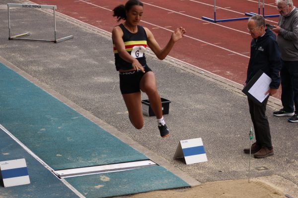 Lady landing in a long jump sand pit
