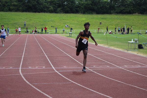 Boy in Walton vest on athletics track