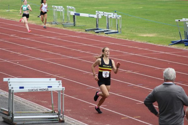 Lady in Walton vest on athletics track