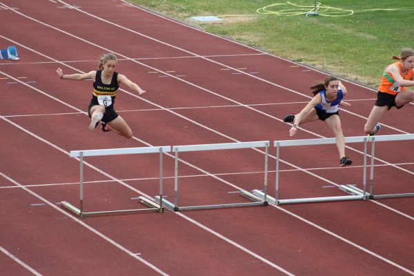 Lady jumping over a hurdle
