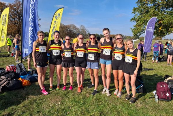 8 women in Walton AC club vests standing on grass