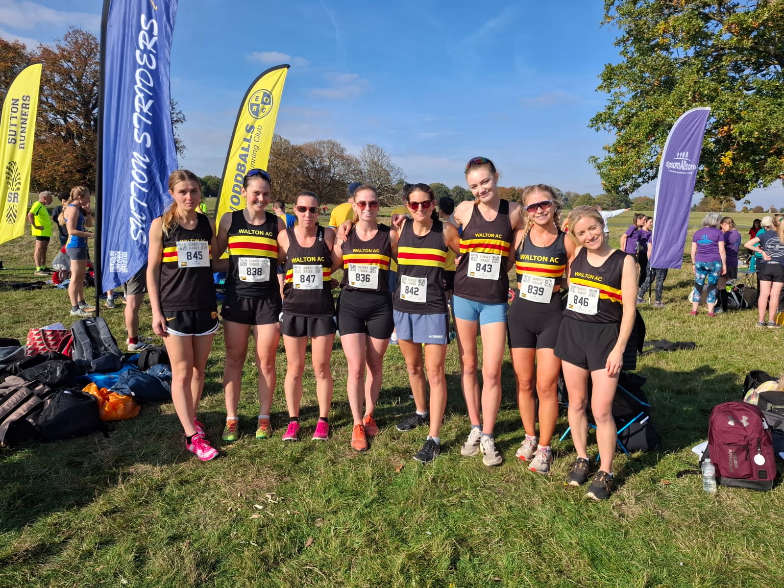 8 women in Walton AC club vests standing on grass